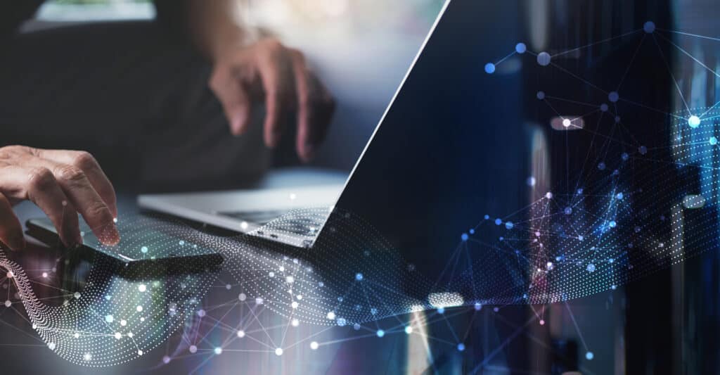 Main sur smartphone et ordinateur avec graphisme de réseau numérique évoquant la connectivité et la technologie.